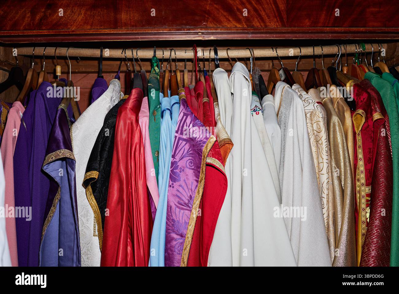 Vêtements liturgiques assortis suspendus dans la garde-robe de l'église pour la cérémonie religieuse Banque D'Images