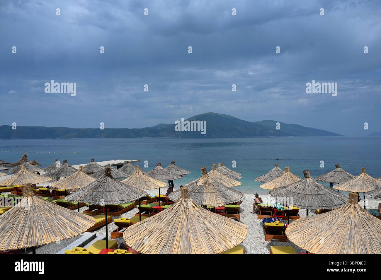 Radhime, Albanie - 17 juin 2025 : parasols et chaises longues sur le village balnéaire Radhime près de la ville de Vlora sur la Riviera albanaise. Banque D'Images