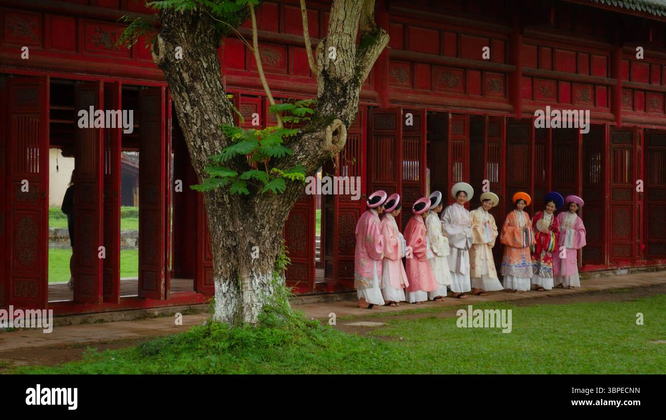 Groupe de femmes en robes áo nhật Bình traditionnelles à la ville impériale, Hue, Vietnam Banque D'Images