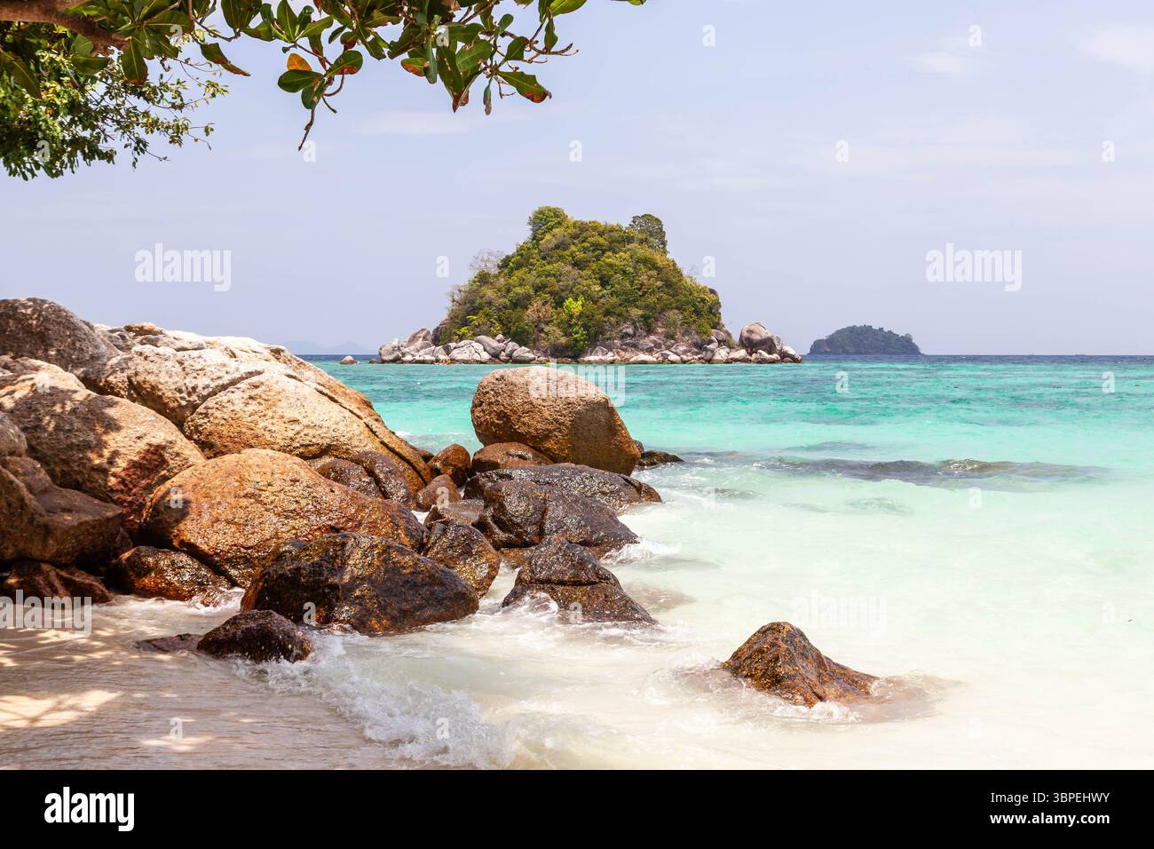 Côte de Koh Lipe, Thaïlande. Une île tropicale avec une eau émeraude cristalline, plage de sable blanc, rochers et ciel bleu. Une destination de vacances. Banque D'Images
