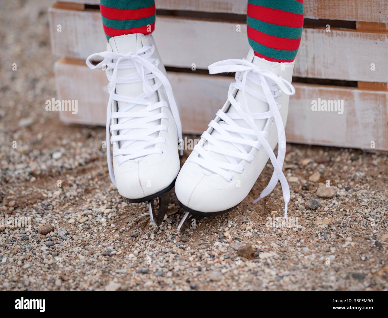 patins blancs bouclés pour femmes sur les pieds des enfants au sol. Banque D'Images