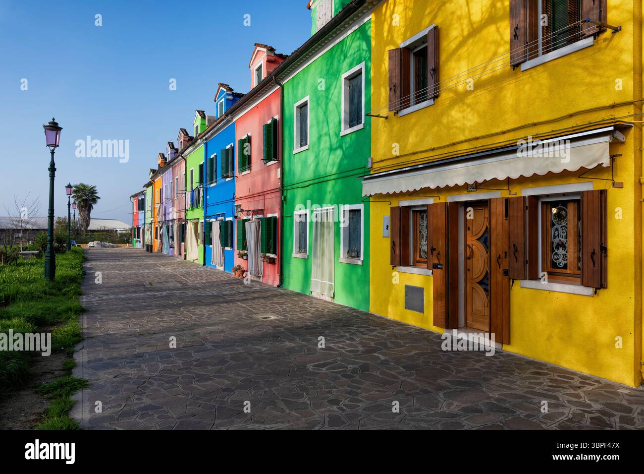 Rangée de maisons aux façades colorées peintes sur l'île de Burano dans la lagune de Venise, Italie. Banque D'Images