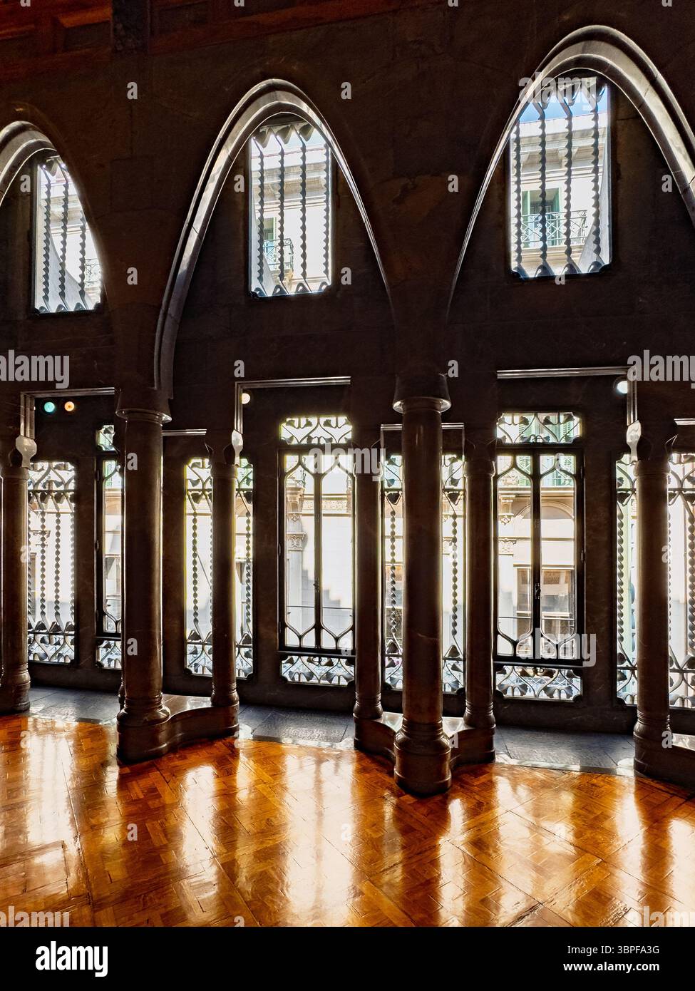 Le grand salon du Palau Güell par Antoni Gaudí, avec des colonnes de marbre poli et de grandes fenêtres créant une lumière spectaculaire, Barcelone, Espagne. Banque D'Images