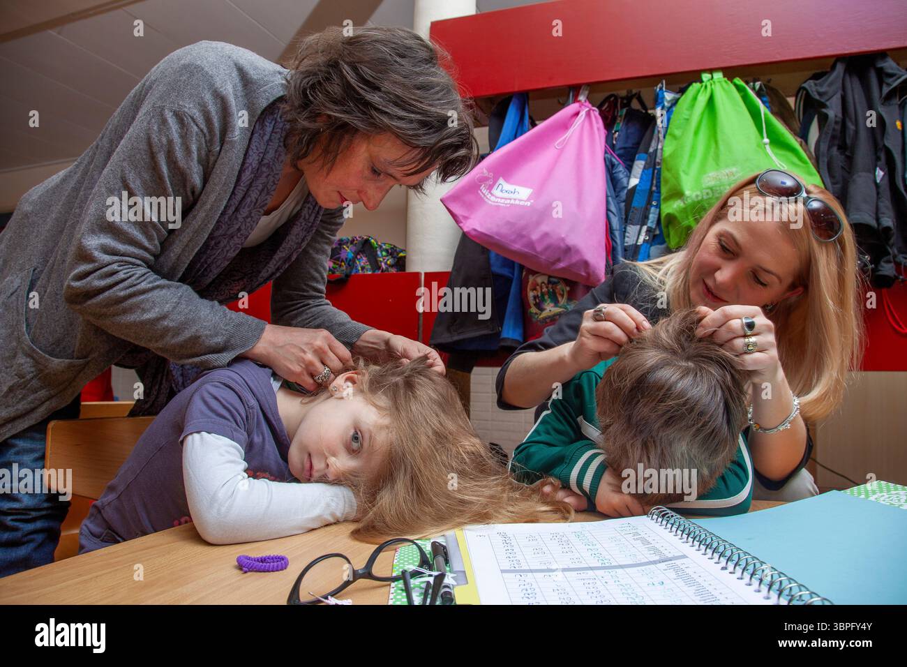 Pays-Bas, Arnhem. École primaire. Les mères sont à la recherche de puces dans les cheveux des écoliers pendant l'école. Banque D'Images