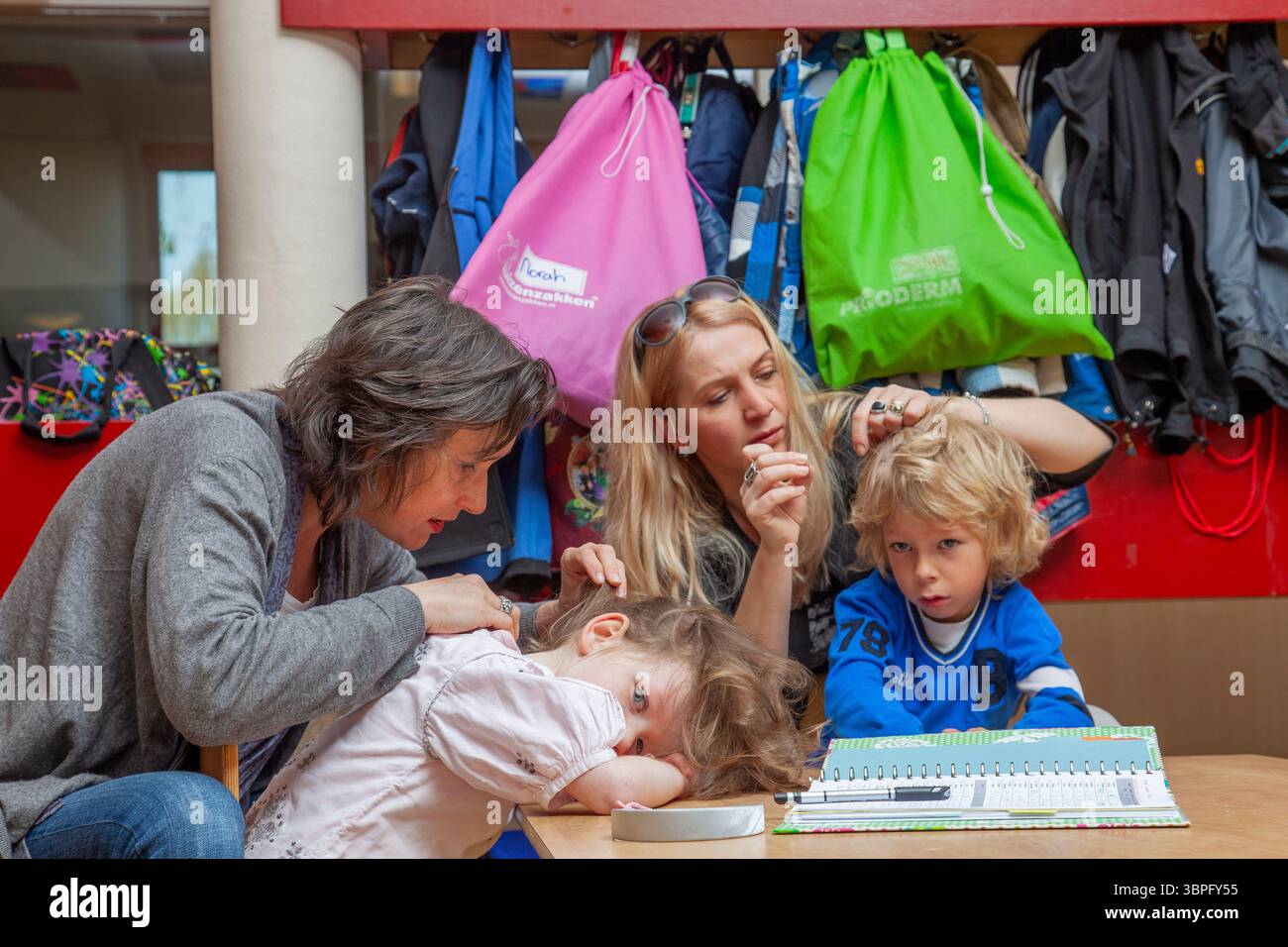 Pays-Bas, Arnhem. École primaire. Les mères sont à la recherche de puces dans les cheveux des écoliers pendant l'école. Banque D'Images