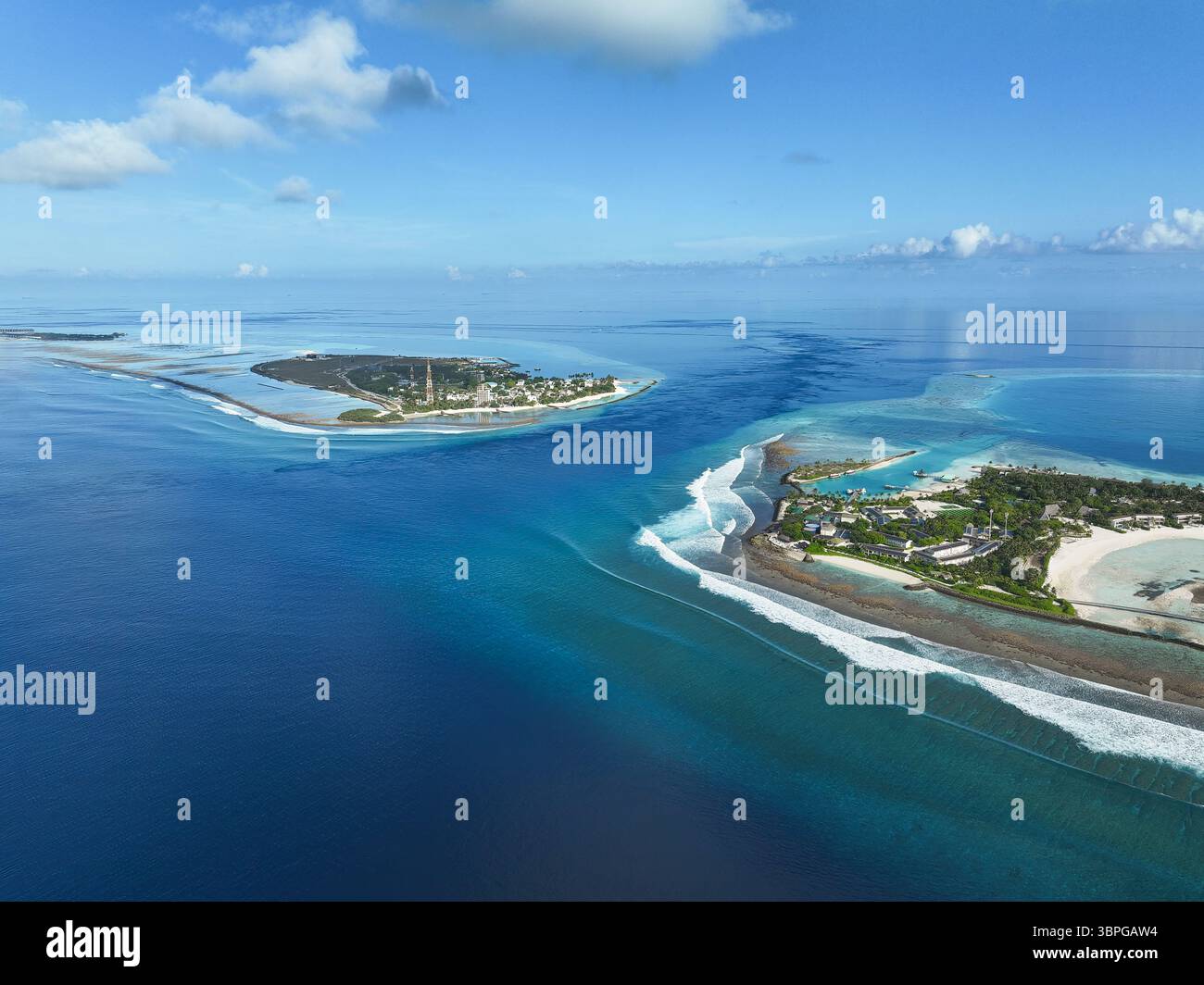 Vue aérienne des îles entourées de lagunes et les spots de surf poulets et Cokes au loin sous un ciel bleu clair par une journée calme, Thulusdhoo, K Banque D'Images