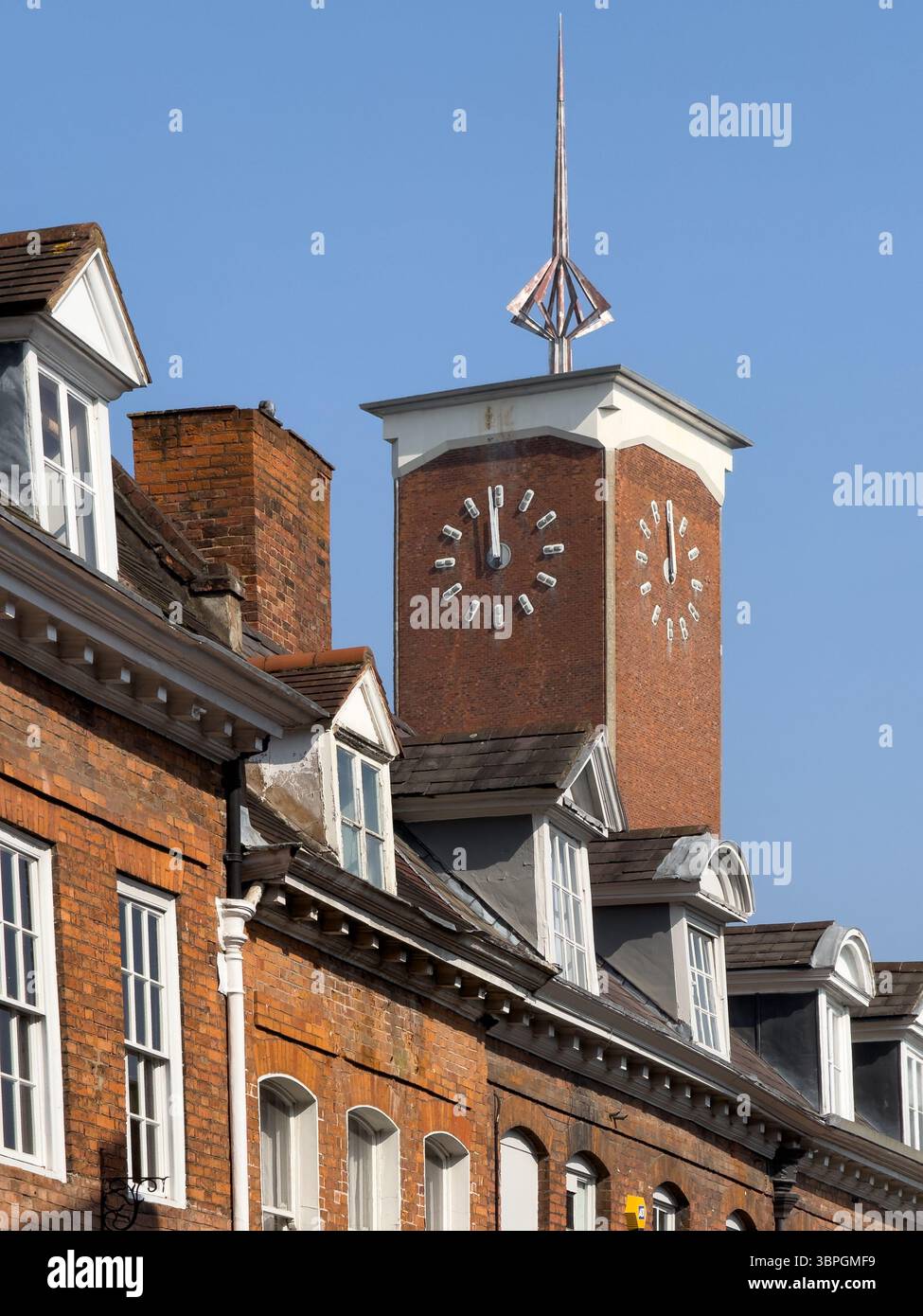 Shrewsbury, Angleterre, Royaume-Uni - 24 mars 2025 ; tour de l'horloge en brique de Shrewsbury Market Hall s'élevant au-dessus de vieilles maisons mitoyennes Banque D'Images