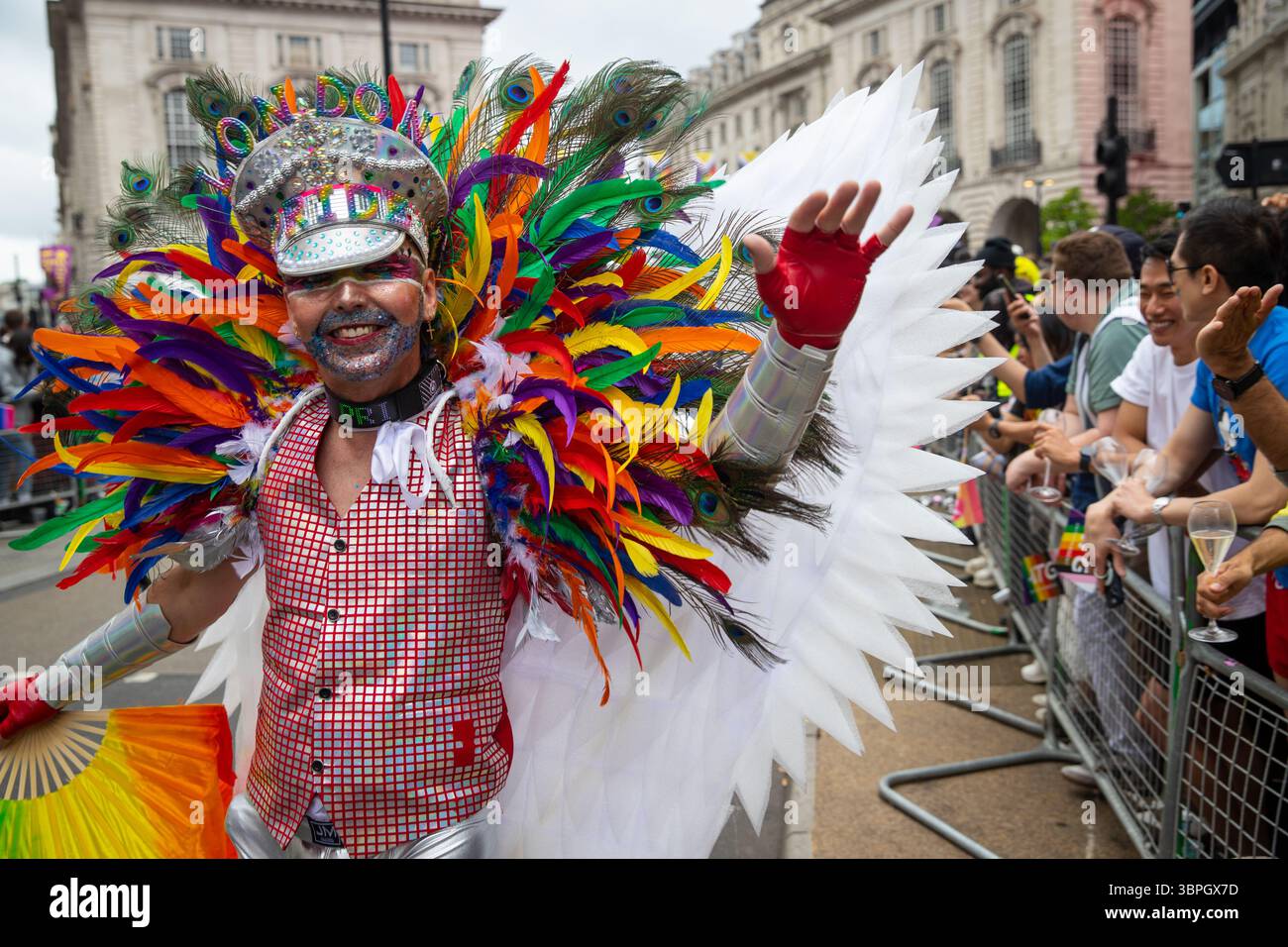 Homme habillé de couleurs vives faisant signe devant la caméra à Pride à Londres 2025 Banque D'Images