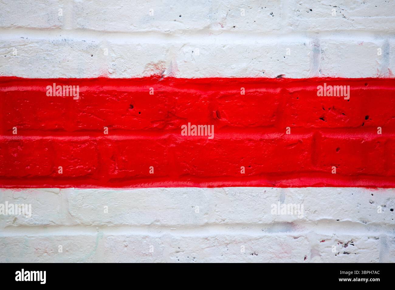 Gros plan de lignes rouges et blanches peintes sur un mur. Banque D'Images