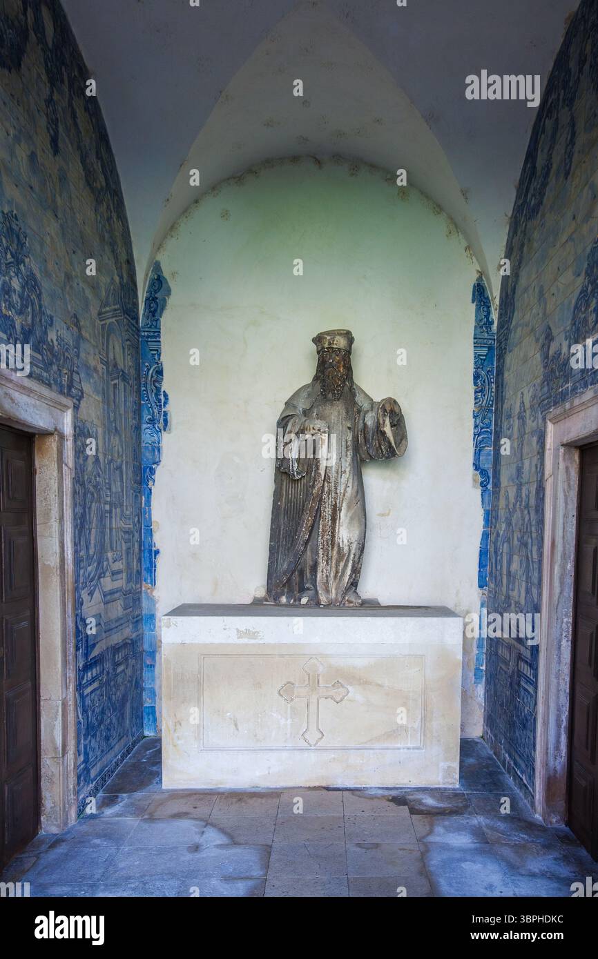 statue en pierre d'un personnage rodé avec une longue barbe, debout sur un simple piédestal orné d'une croix, situé dans une alcôve voûtée avec bleu et blanc Banque D'Images