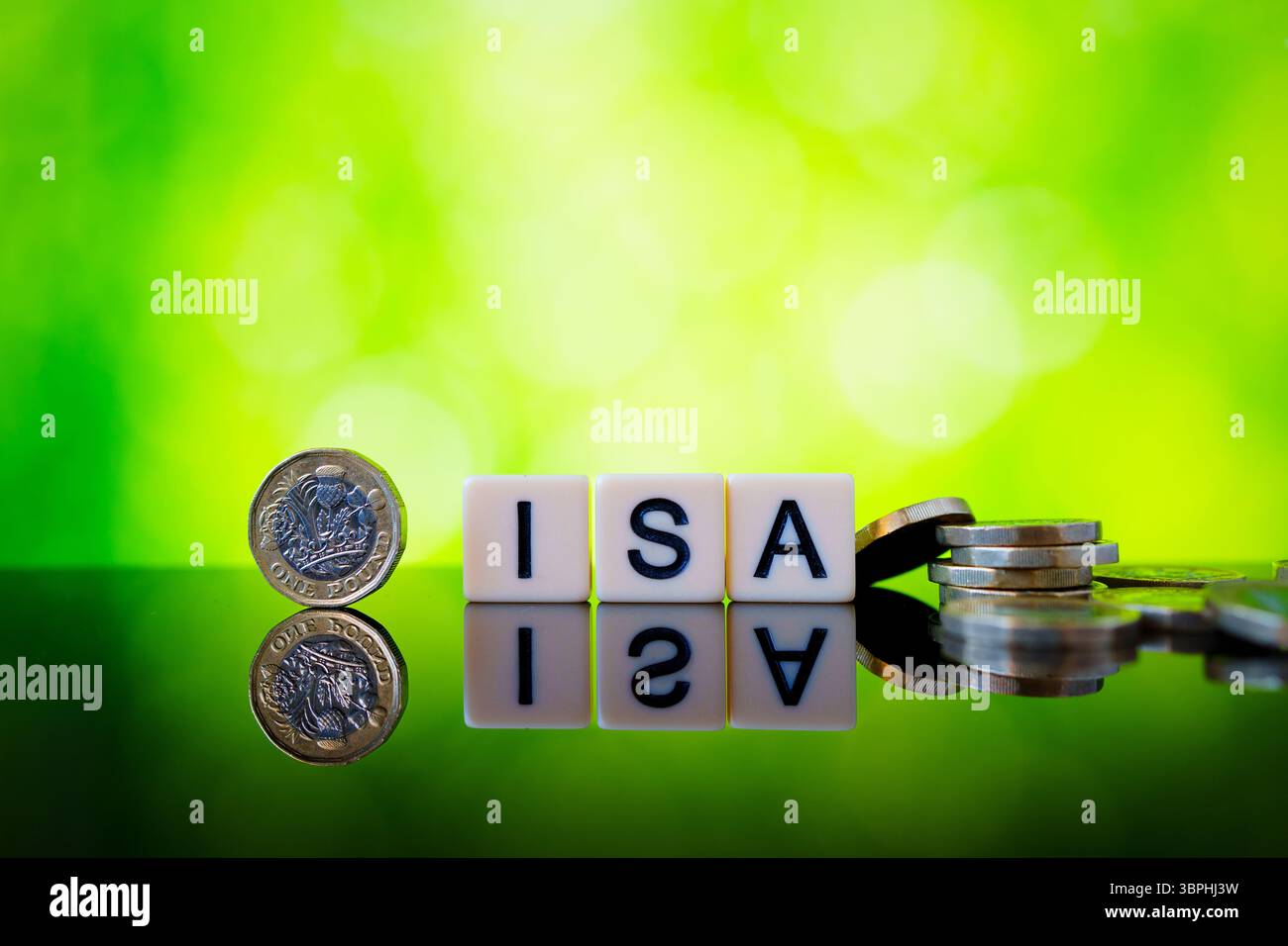 Image brillante de cubes de lettre ISA avec une pièce de livre droite et des pièces en livres sterling dispersées illustrant les options d'épargne et d'investissement britanniques libres d'impôt. Banque D'Images