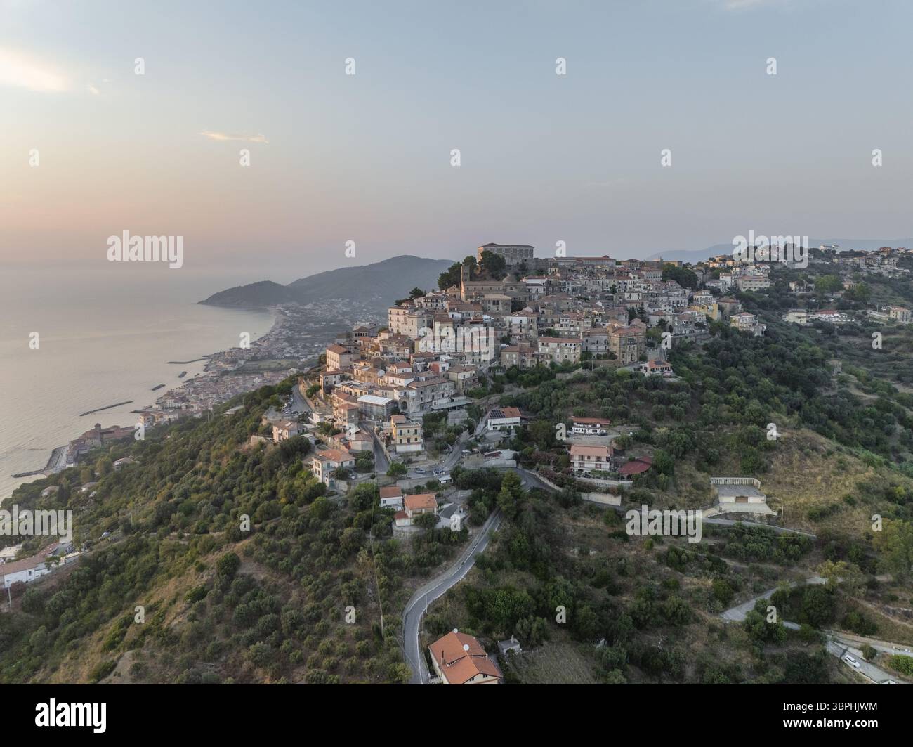 Vue aérienne du charmant village perché sur une colline, embrassé par la lueur chaude du soleil couchant, surplombant la mer Tyrrhénienne, Santa Maria di Castellabate, Salerne, Italie. Banque D'Images