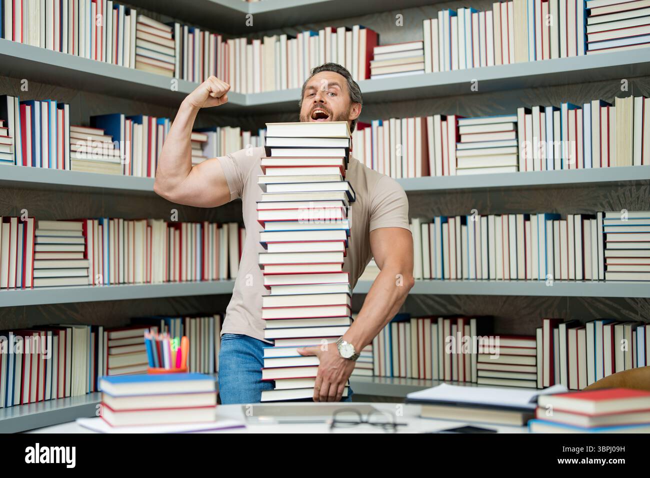 Drôle d'enseignant de tenir beaucoup de livres. Professeur fou avec des livres. Enseignant enthousiaste dans la bibliothèque de livres de l'école. Examen universitaire. Étudier enseigner à l'université. Éducateur Banque D'Images