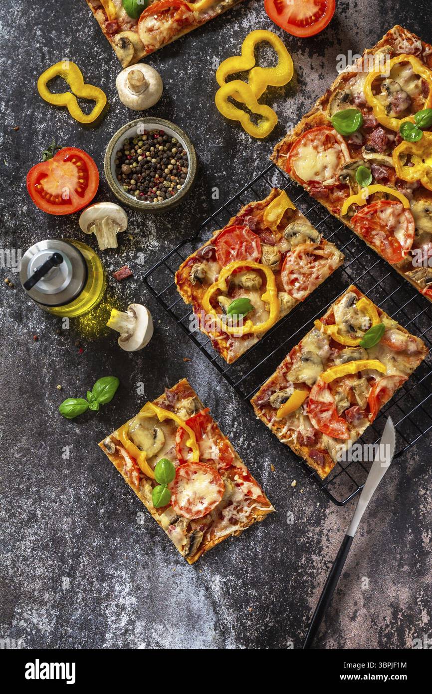 Pizza maison de style Détroit. Grande pizza rectangulaire Pepperoni aux champignons, salami et fromage sur une table en pierre. Vue de dessus du fond de plan plat Banque D'Images