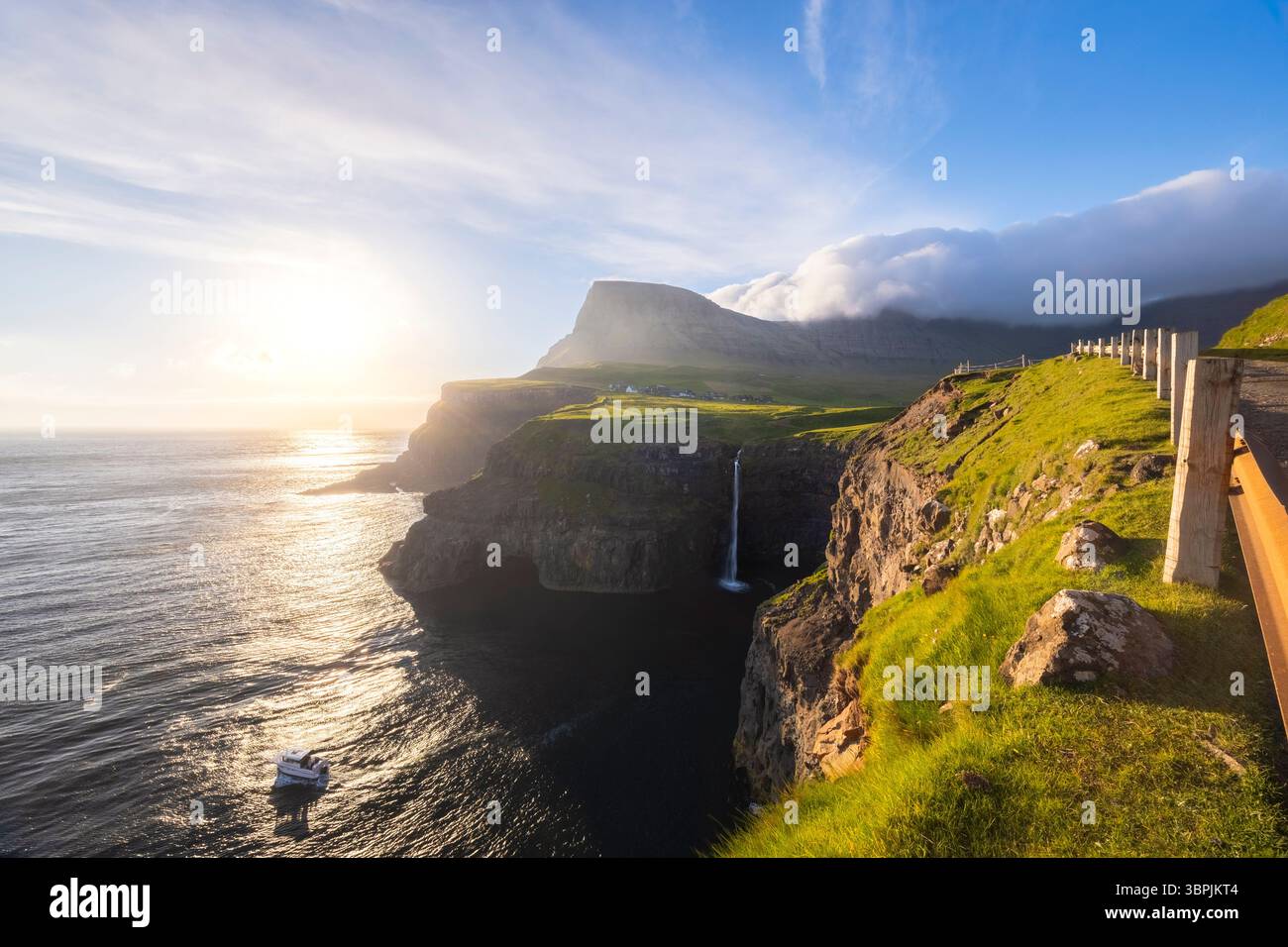 Vue sur la cascade de Mulafossur avec le petit village de Gasadalur. Île de Vagar, Îles Féroé, Danemark, Europe. Banque D'Images