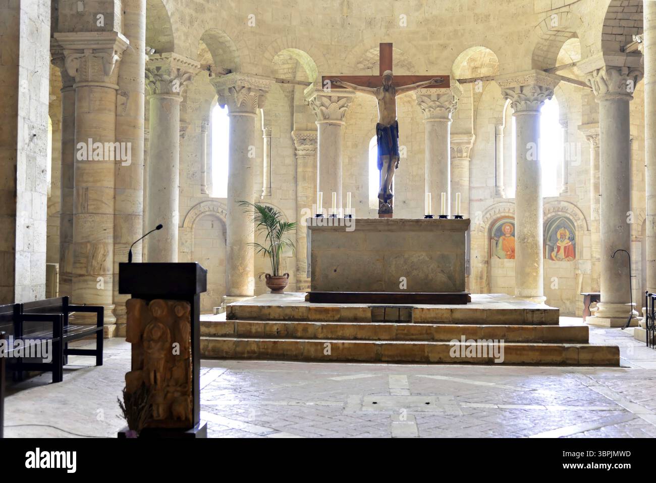Intérieur spacieux de l'église avec croix, chandelles d'autel et architecture richement décorée, église abbatiale Abbazia di Sant'Antimo, près de Montalcino, province o Banque D'Images