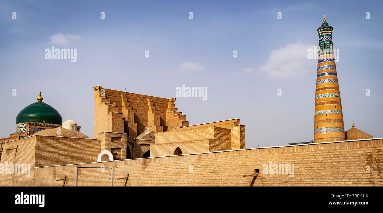 Une vue imprenable sur l'architecture historique avec un dôme vert, des briques complexes et un minaret coloré dans un ciel dégagé. Banque D'Images Une vue imprenable sur l'architecture historique avec un dôme vert, des briques complexes et un minaret coloré dans un ciel dégagé. Banque D'Images