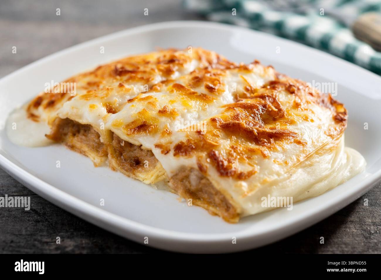 Cannelloni cuit au four avec fromage et sauce béchamel sur table en bois Banque D'Images