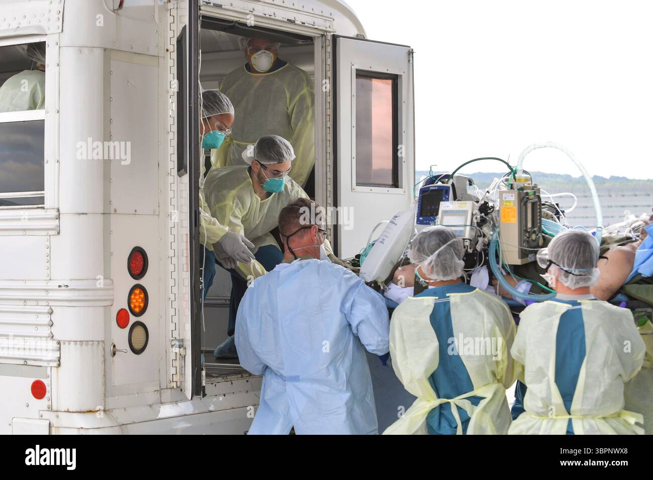 1er juillet 2020 - base aérienne de Ramstein, Rhénanie-Palatinat, Allemagne - les aviateurs affectés au 86e Groupe médical et au 313e Escadron de soutien aux opérations expéditionnaires transfèrent un patient COVID-19 après la toute première utilisation opérationnelle du Conex sous pression négative pour transporter 12 patients à bord d'un avion C-17 Globemaster III à la base aérienne de Ramstein, Allemagne, pour recevoir des soins de niveau supérieur au Centre médical régional de Landstuhl, Allemagne. La NPC est la dernière chambre de confinement isolée développée pour transporter jusqu’à 28 personnes atteintes de maladies infectieuses. (Image de crédit : © John Wright/U.S. Banque D'Images