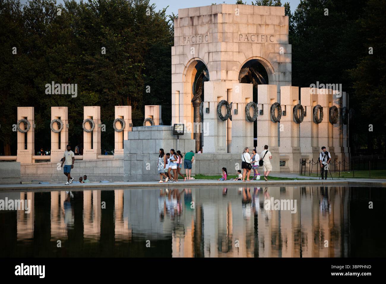 WASHINGTON DC — le Mémorial national de la seconde Guerre mondiale se reflète dans les eaux calmes du bassin réfléchissant du National Mall. Le mémorial, inauguré en 2004, rend hommage aux 16 millions d'Américains qui ont servi dans les forces armées pendant la seconde Guerre mondiale et aux plus de 400 000 morts dans le conflit. Le mémorial comprend 56 piliers de granit représentant les états et territoires américains, disposés autour d'une place centrale avec des fontaines. Situé entre le Lincoln Memorial et le Washington Monument, le mémorial se trouve à l'extrémité ouest du Reflecting Pool, qui a été construit à l'origine en 1922 dans le cadre de l'église Banque D'Images