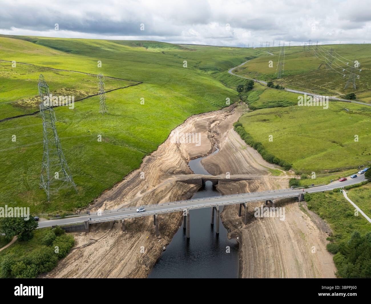 Terre fissurée sèche au réservoir Baitings à Ripponden, West Yorkshire. Les ménages du Yorkshire sont devenus les premiers à être frappés par une interdiction de canalisations par Yorkshire Water, après des mois de temps extrêmement chaud et sec à travers l'Angleterre. Date de la photo : mercredi 9 juillet 2025. Banque D'Images