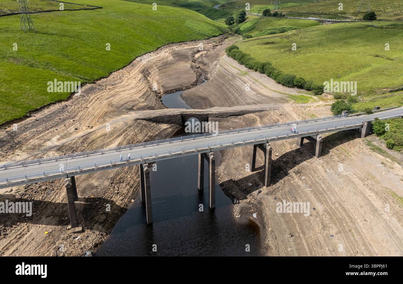 Terre fissurée sèche au réservoir Baitings à Ripponden, West Yorkshire. Les ménages du Yorkshire sont devenus les premiers à être frappés par une interdiction de canalisations par Yorkshire Water, après des mois de temps extrêmement chaud et sec à travers l'Angleterre. Date de la photo : mercredi 9 juillet 2025. Banque D'Images
