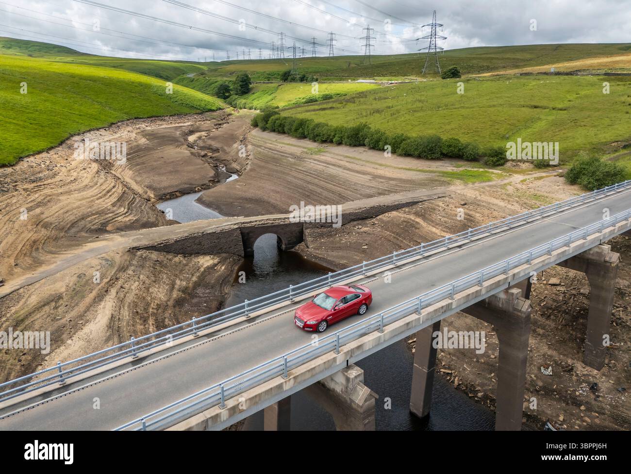 Terre fissurée sèche au réservoir Baitings à Ripponden, West Yorkshire. Les ménages du Yorkshire sont devenus les premiers à être frappés par une interdiction de canalisations par Yorkshire Water, après des mois de temps extrêmement chaud et sec à travers l'Angleterre. Date de la photo : mercredi 9 juillet 2025. Banque D'Images