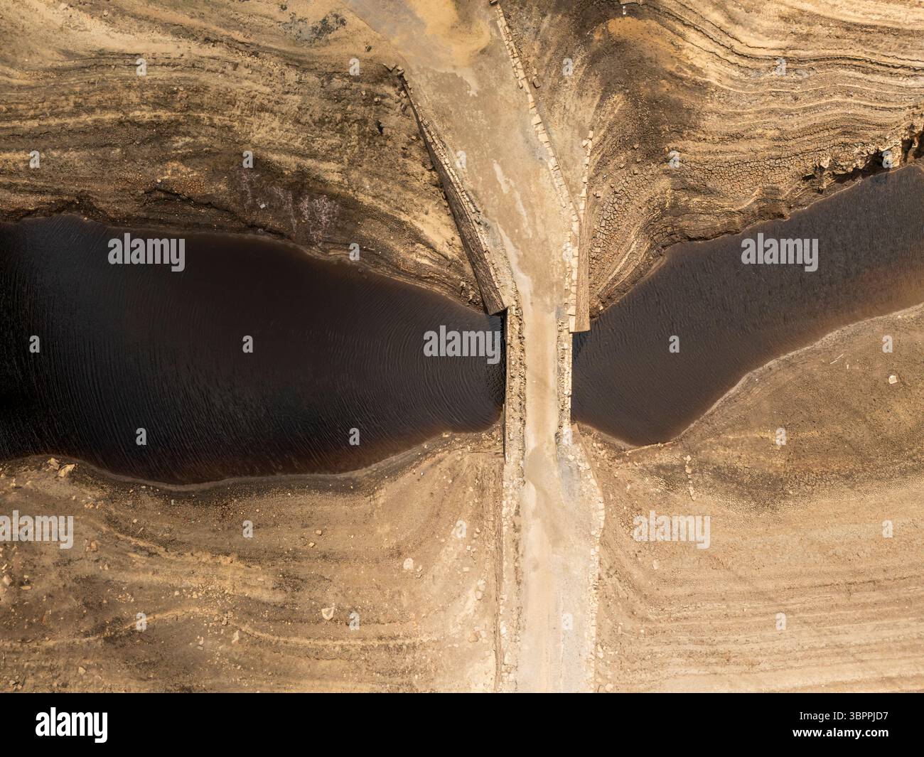 Terre fissurée sèche au réservoir Baitings à Ripponden, West Yorkshire. Les ménages du Yorkshire sont devenus les premiers à être frappés par une interdiction de canalisations par Yorkshire Water, après des mois de temps extrêmement chaud et sec à travers l'Angleterre. Date de la photo : mercredi 9 juillet 2025. Banque D'Images