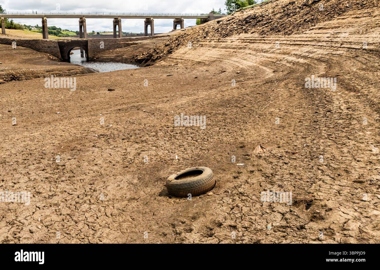 Terre fissurée sèche au réservoir Baitings à Ripponden, West Yorkshire. Les ménages du Yorkshire sont devenus les premiers à être frappés par une interdiction de canalisations par Yorkshire Water, après des mois de temps extrêmement chaud et sec à travers l'Angleterre. Date de la photo : mercredi 9 juillet 2025. Banque D'Images