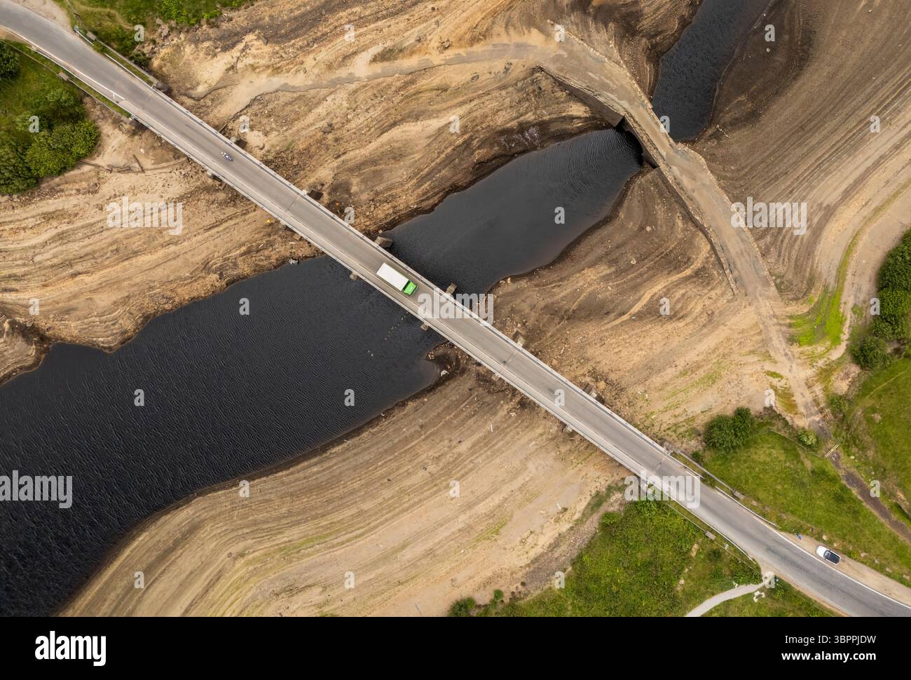 Terre fissurée sèche au réservoir Baitings à Ripponden, West Yorkshire. Les ménages du Yorkshire sont devenus les premiers à être frappés par une interdiction de canalisations par Yorkshire Water, après des mois de temps extrêmement chaud et sec à travers l'Angleterre. Date de la photo : mercredi 9 juillet 2025. Banque D'Images