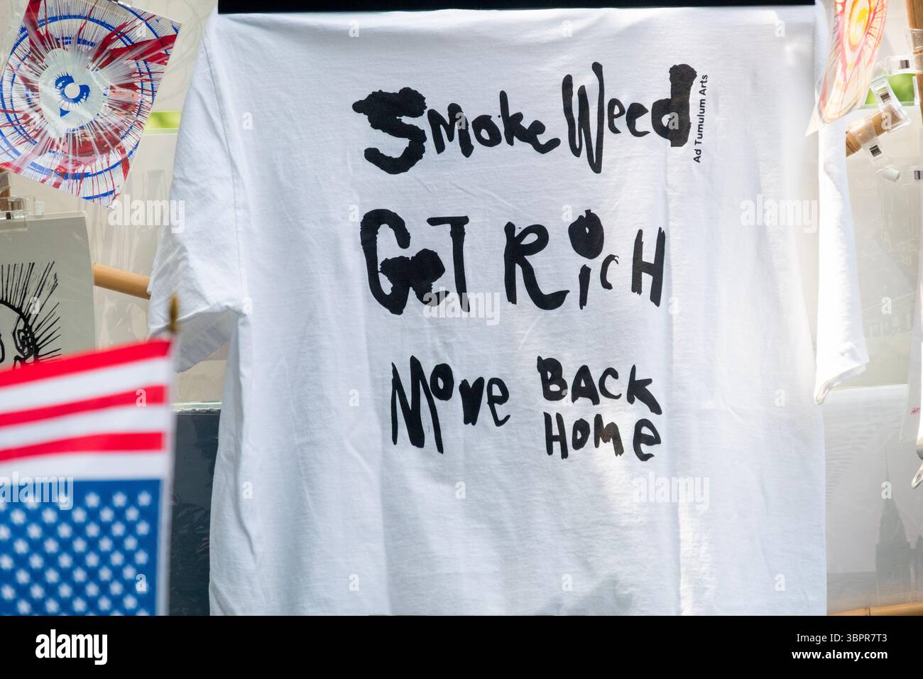 Un mystérieux tee-shirt disant « Smoke Weed Get Rich Move Back Home ». En vente à Washington Square Park, Greenwich Village, New York. Banque D'Images