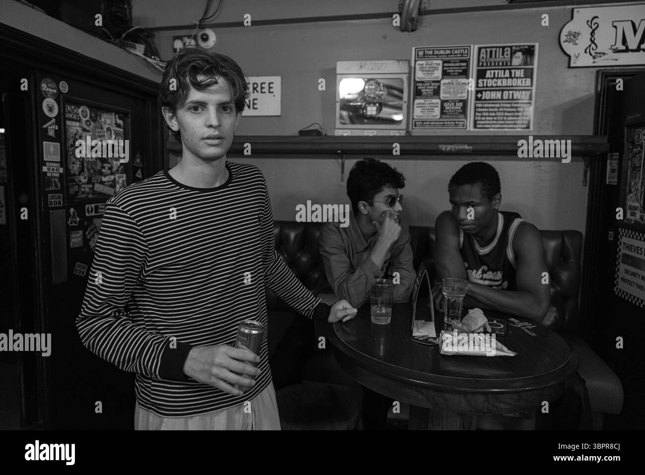 Les jeunes étudiants d'Eton College profitent d'une fête animée dans un pub londonien traditionnel, partageant rire et camaraderie autour d'un verre. Banque D'Images