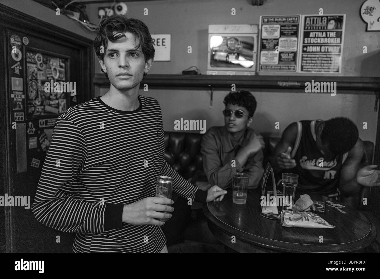 Les jeunes étudiants d'Eton College profitent d'une fête animée dans un pub londonien traditionnel, partageant rire et camaraderie autour d'un verre. Banque D'Images