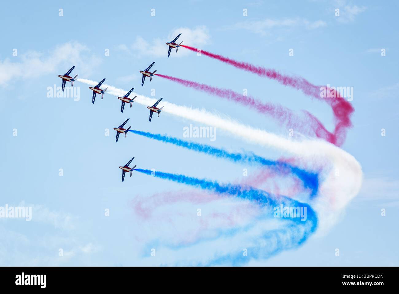Les huit AlphaJets de la patrouille de France volent en formation de cygne avec de la fumée bleue, blanche et rouge lors d'une exposition aérienne. Banque D'Images