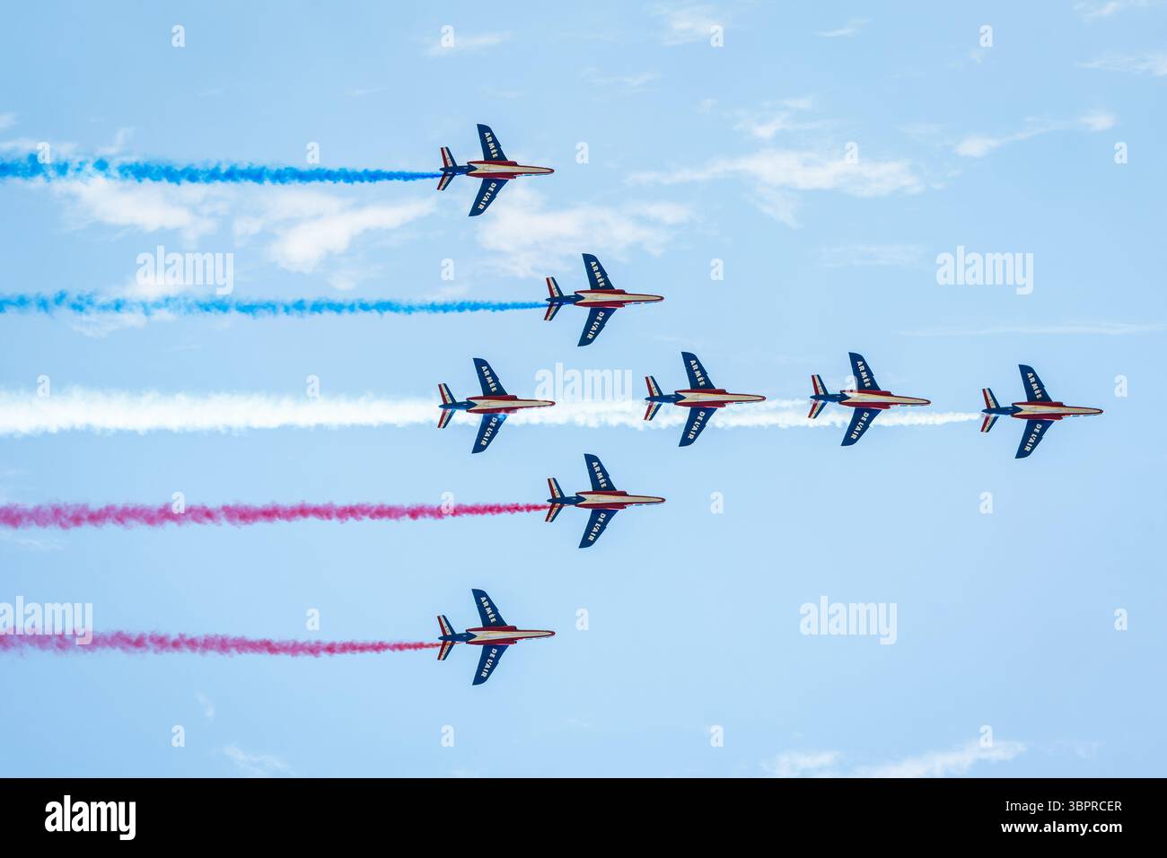 Les huit AlphaJets de la patrouille de France volent en formation de cygne avec de la fumée bleue, blanche et rouge lors d'une exposition aérienne. Banque D'Images
