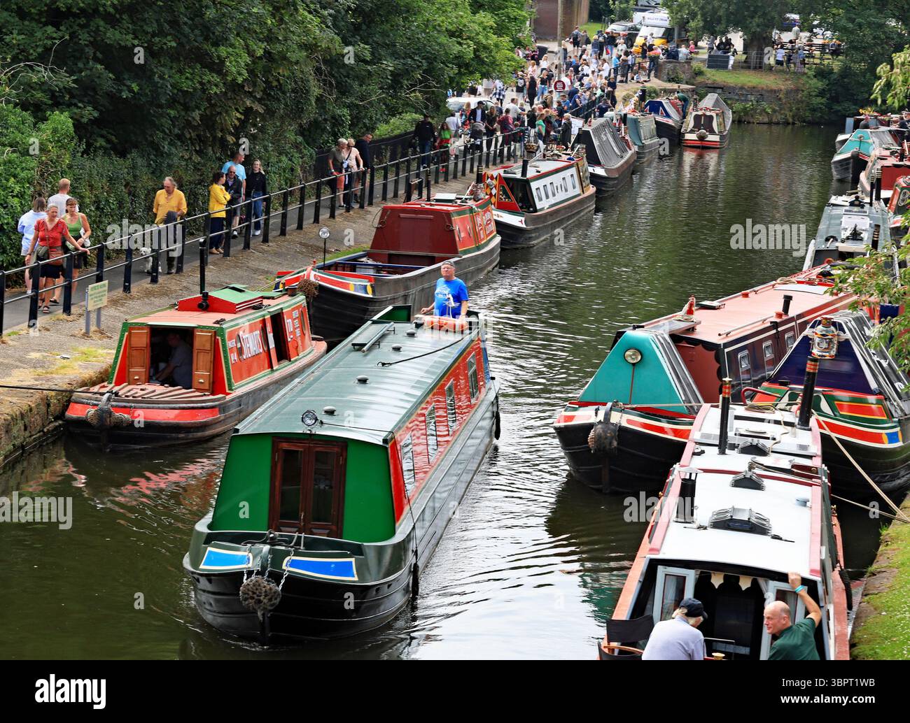 Un bateau de location de vacances sur le canal de la compagnie Andersen Boats passe devant les foules de gens sur la rive du canal Bridgewater pour le jour de transport Lymm Banque D'Images