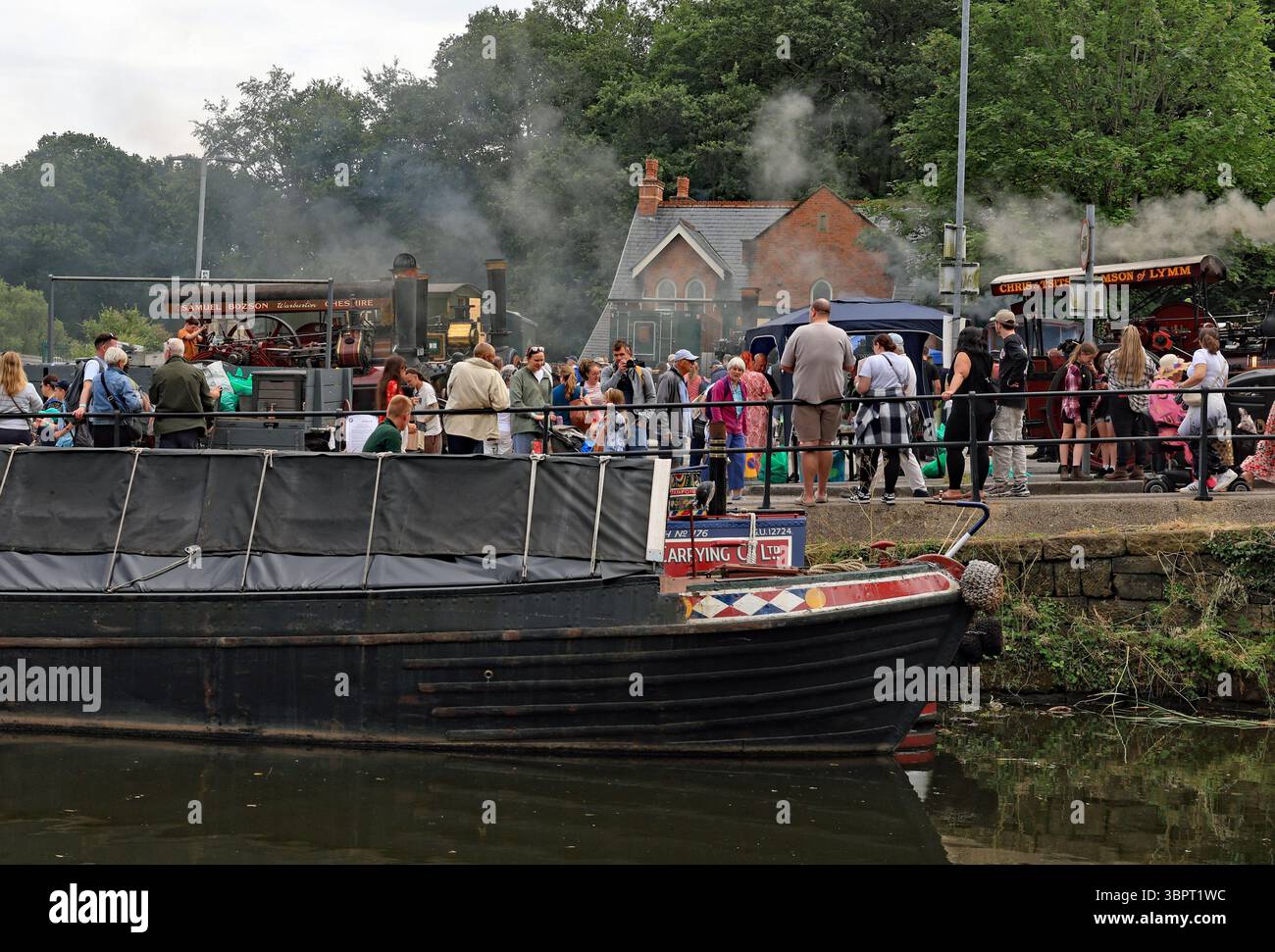Les anciens bateaux de travail sont amarrés le long des rives du canal de Bridgewater devant les moteurs de traction fumants en ville pour la journée de transport Lymm Banque D'Images
