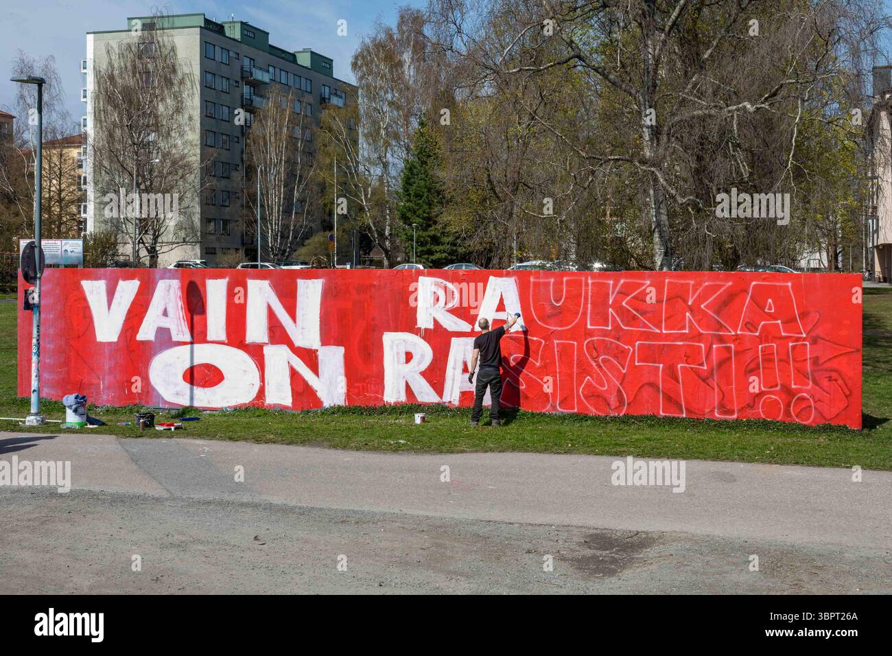 Vain raukka sur rasisti ! ! Homme peignant un grand graffiti dans le quartier Amuri de Tampere, Finlande Banque D'Images