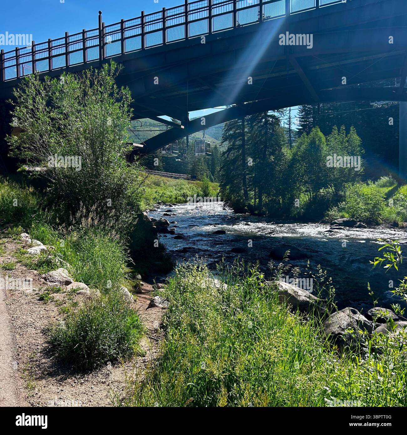 Rivière de montagne coulant sous un grand pont par un jour ensoleillé lumineux - Image de stock capturée avec un smartphone