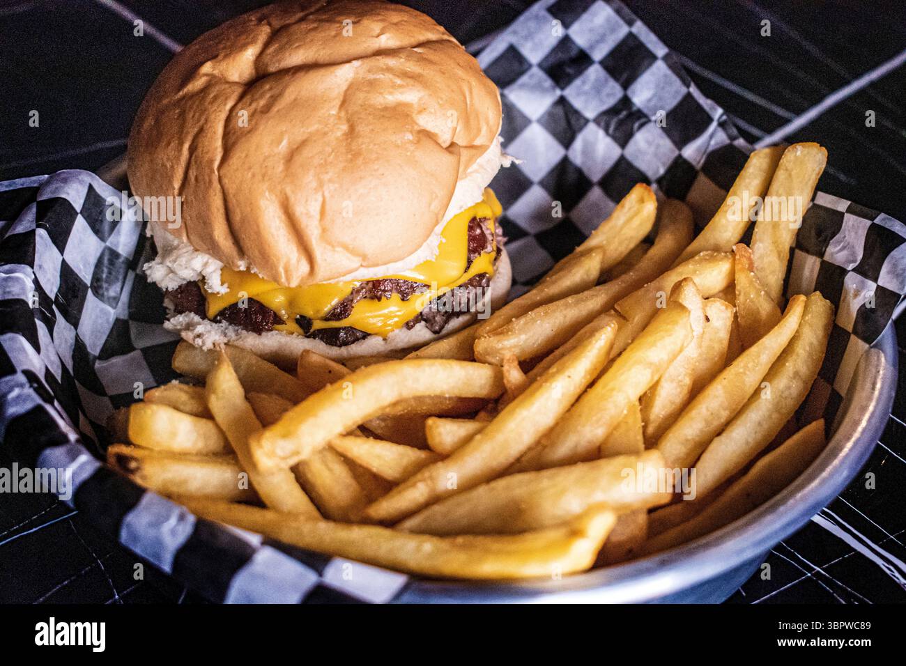 Hamburger double avec fromage cheddar et frites. Cuisine gastronomique. Restauration rapide. Banque D'Images