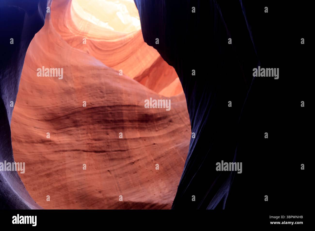 Une lumière brillante illumine les formations tourbillonnantes de grès d'Antelope Canyon, créant un contraste visuel époustouflant au cœur de page Banque D'Images