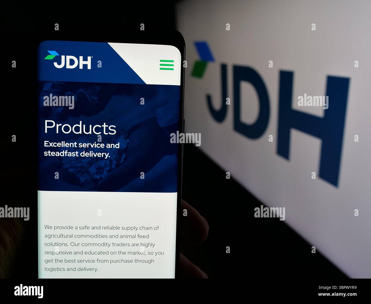 Stuttgart, Allemagne - 05-07-2025 : personne tenant un téléphone portable avec la page web de la société américaine J.D. Heiskell Holdings LLC (JDH) sur l'écran devant le logo. Banque D'Images