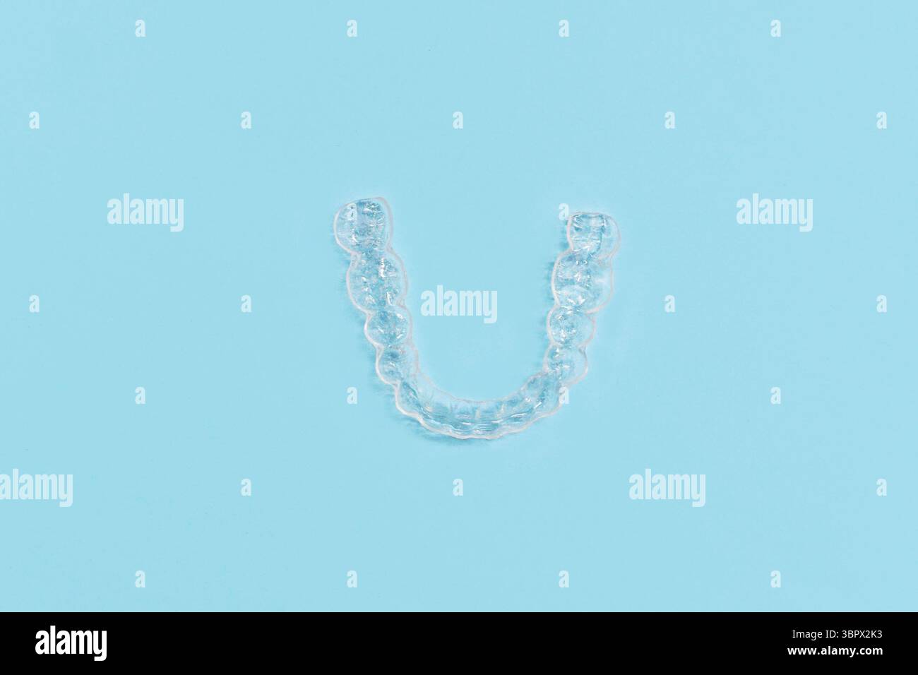 Vue de dessus de dents dentaires transparentes personnalisées protège-morsures aligners clairs pour la mâchoire inférieure sur fond bleu Banque D'Images