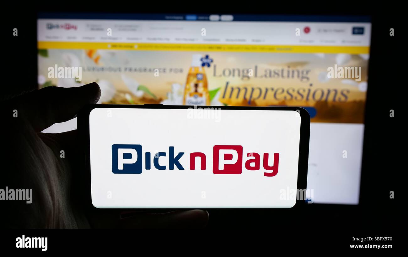 Stuttgart, Allemagne - 2025-05-05 : personne tenant un téléphone portable avec le logo de l'entreprise de vente au détail d'épicerie Pick n Pay Group Ltd sur l'écran devant la page Web. Banque D'Images