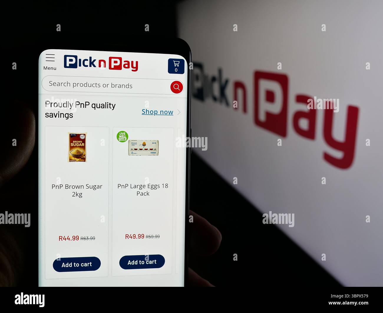 Stuttgart, Allemagne - 2025-05-05 : personne tenant un téléphone portable avec la page Web de l'entreprise de vente au détail d'épicerie Pick n Pay Group Ltd sur l'écran devant le logo Banque D'Images