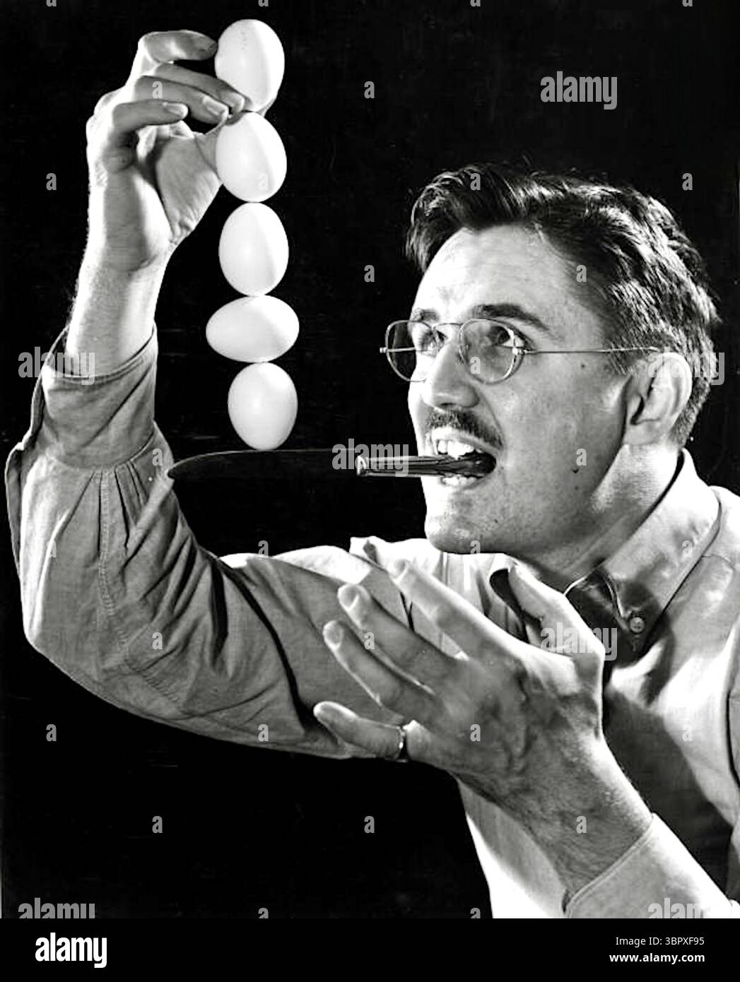 Joe Steinmetz faisant un acte d'équilibrage d'oeuf sur le bord d'un couteau - 1939 Banque D'Images