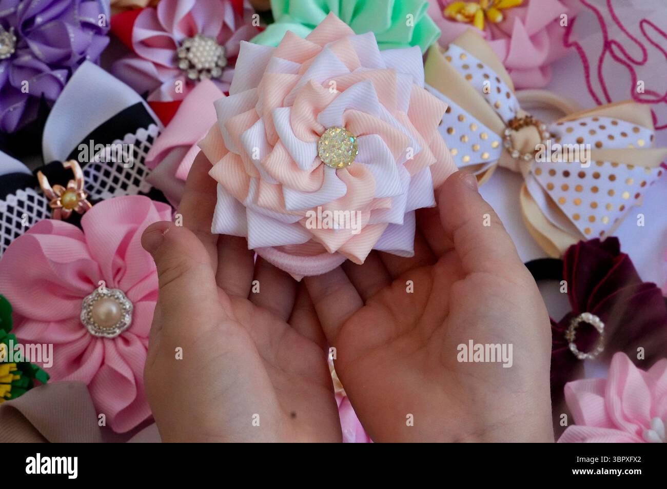 Ornement pour cheveux. Mains des enfants tenant l'ornement Banque D'Images