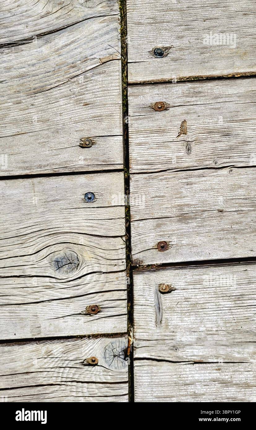 Gros plan détaillé d'un mur en bois rustique avec des lattes altérées et de tons gris disposées dans un motif décalé Banque D'Images