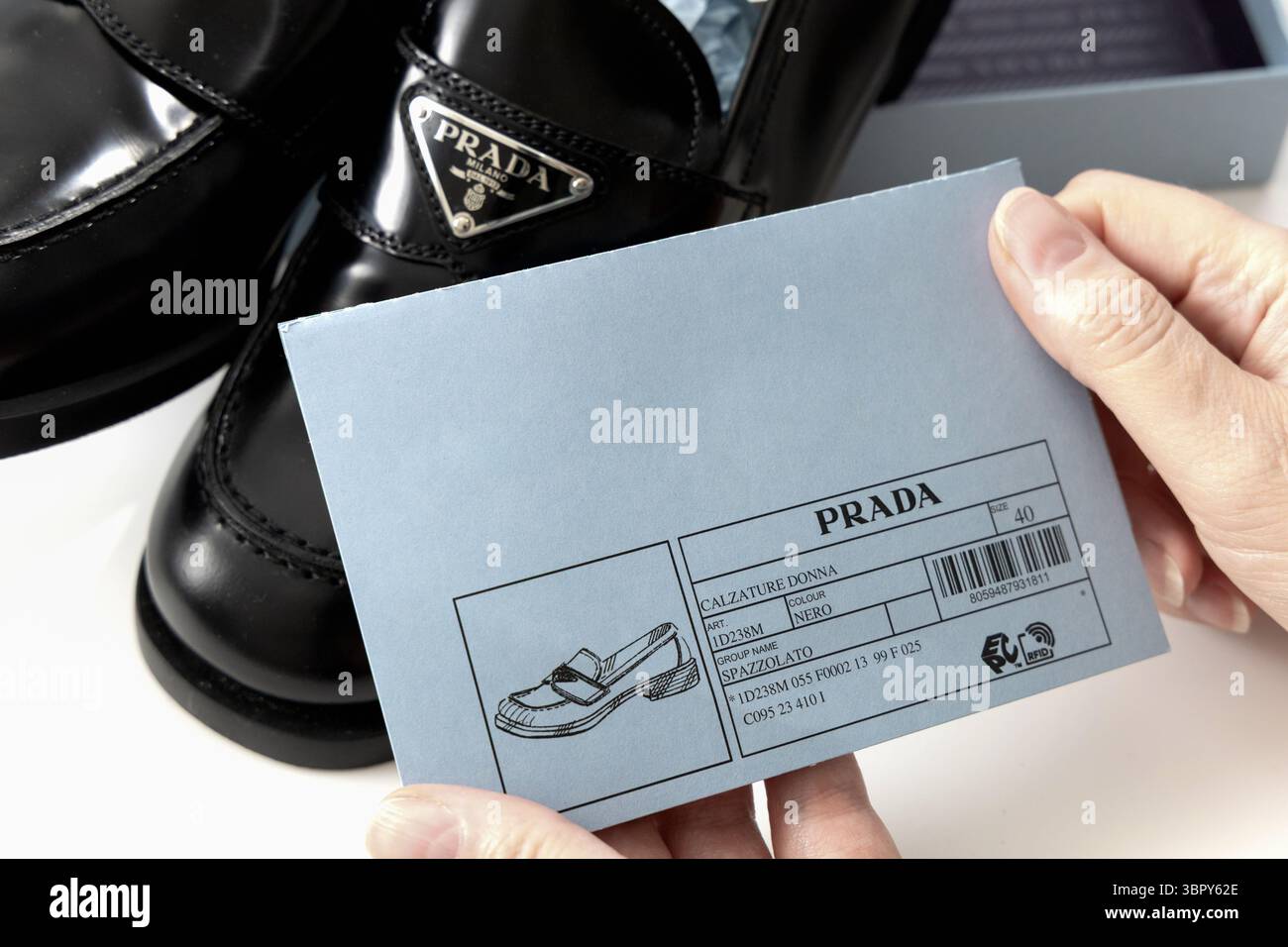 Mains familiales tenant une étiquette Prada indiquant la taille et la couleur des chaussures. Copenhague, Danemark - 10 juillet 2025 Banque D'Images