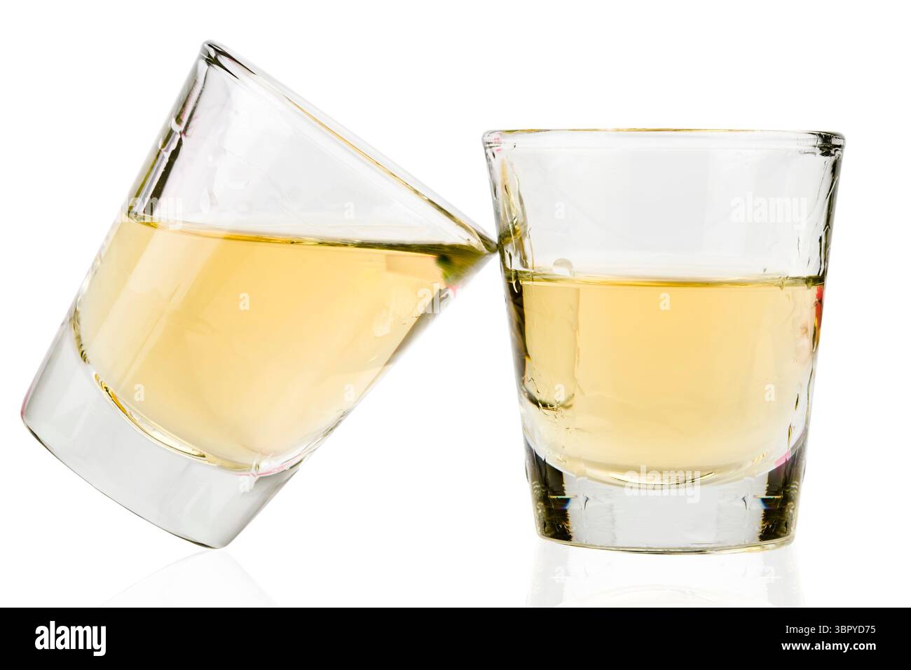 deux coups de tequila, un verre appuyé sur l'autre sur fond blanc Banque D'Images